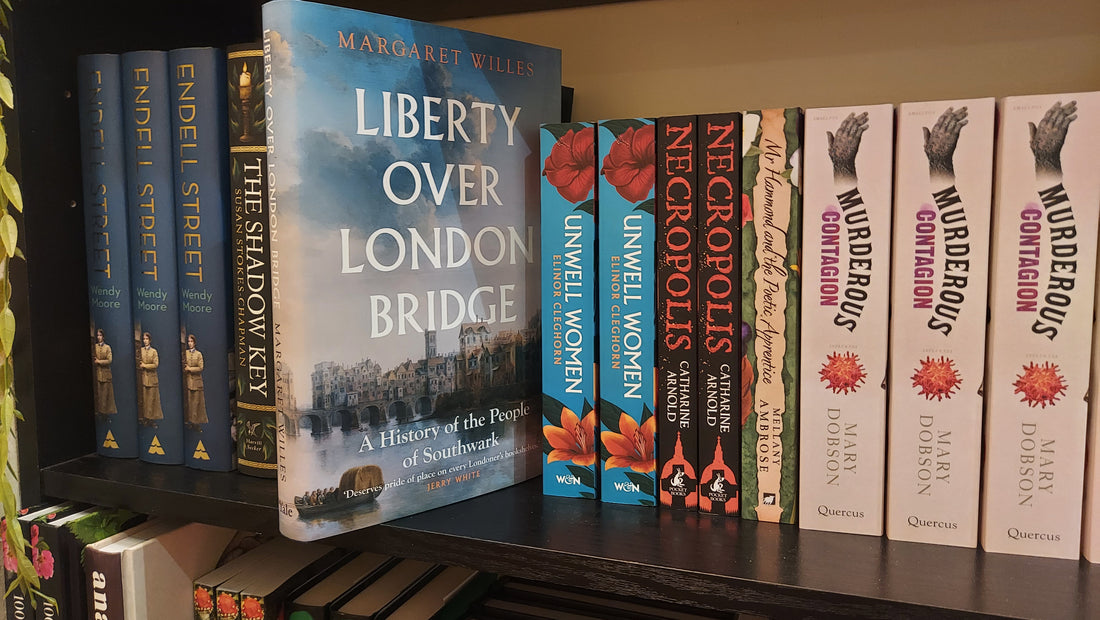 A row of books on a shelf, with Liberty over London Bridge pulled out to display its front cover