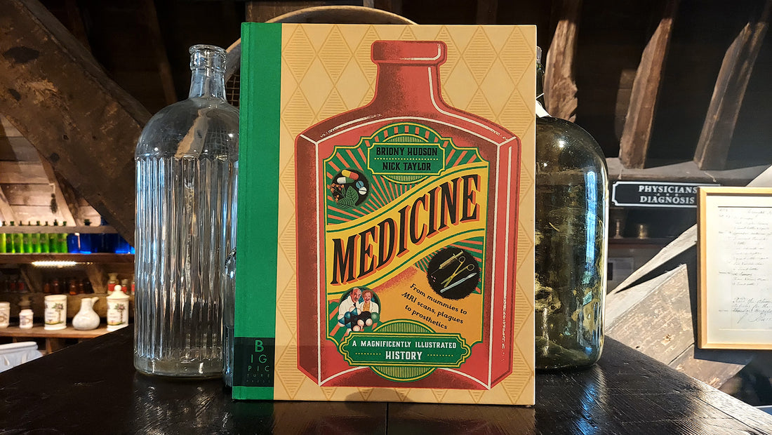 The Medicine book placed upright next to glass bottles in the museum