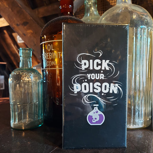 The Pick Your Poison game box next to medicinal glass bottles in the museum