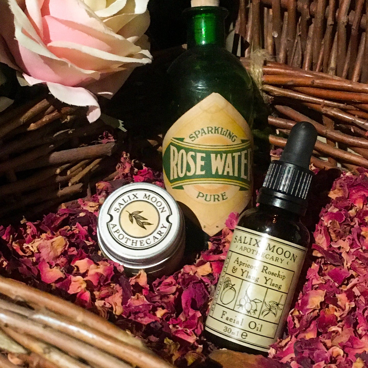 A bottle of facial oil nestled amongst dried rose petals