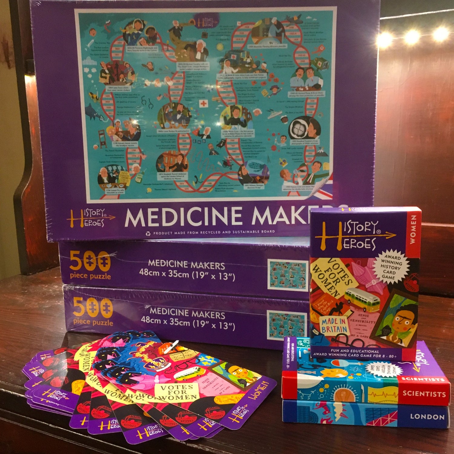 Three Medicine Makers jigsaw boxes; boxes of Women, Scientists and London History Heroes; and some of the History Heroes Women cards spread out on the table
