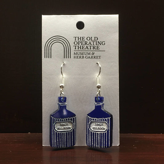 Pair of blue dangle earrings in the shape of a bottle with the label 'tinct. belladon'