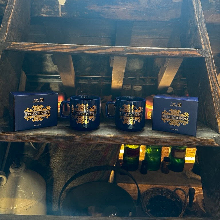 Three blue mugs with gold text on a wooden shelf with a rustic background.