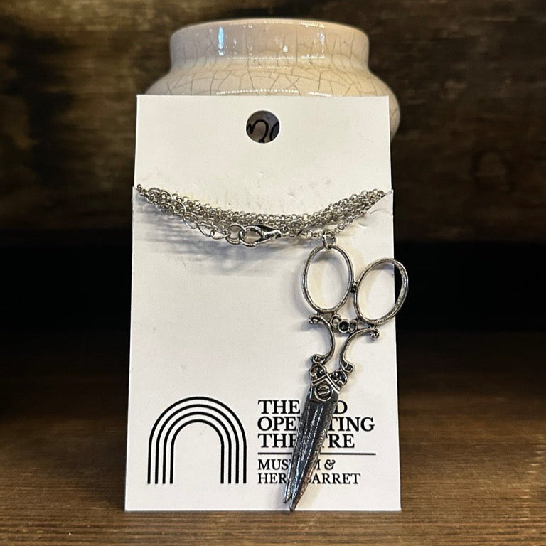 Necklace with pendant on a card against a wooden background
