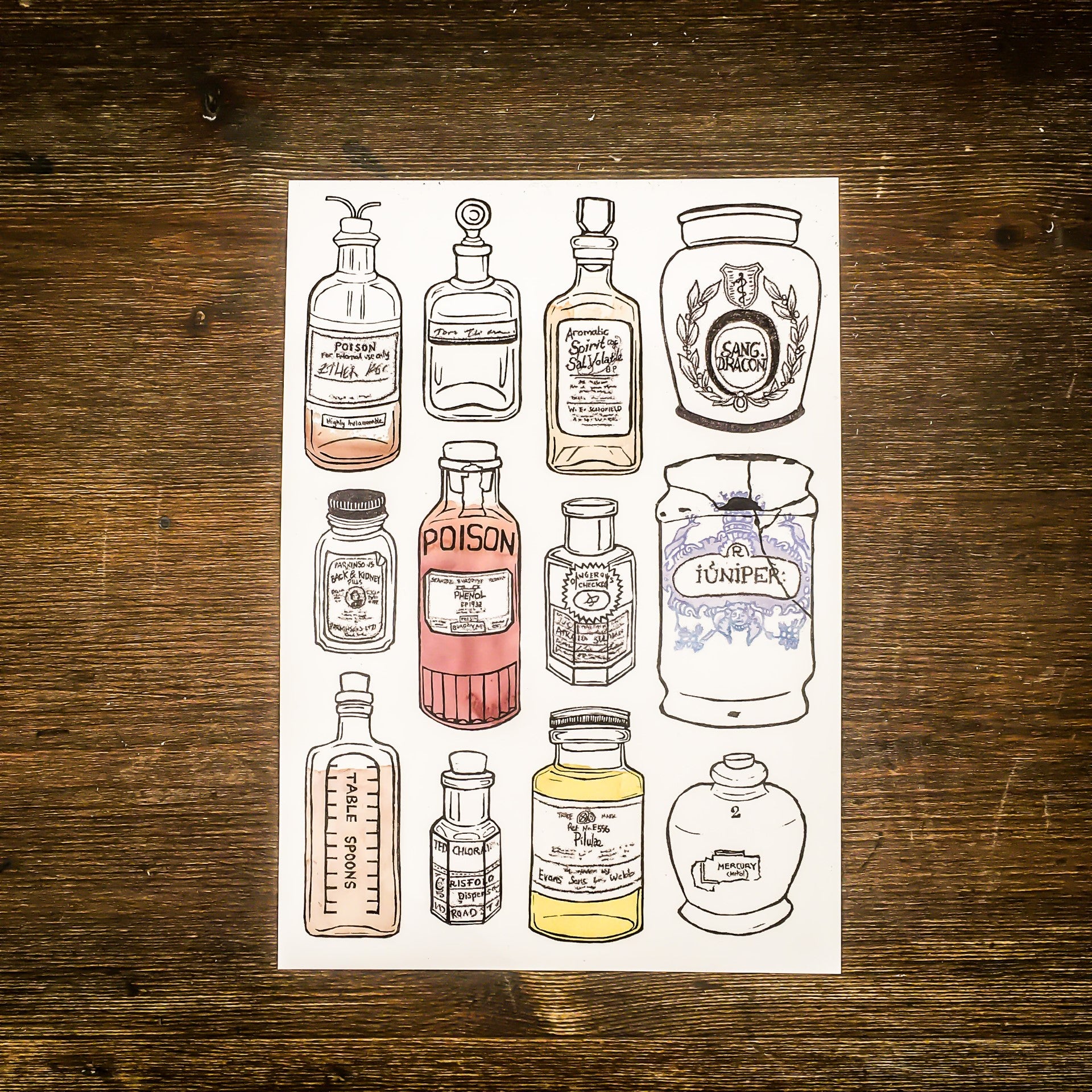 A card with the apothecary bottles design on a wooden surface