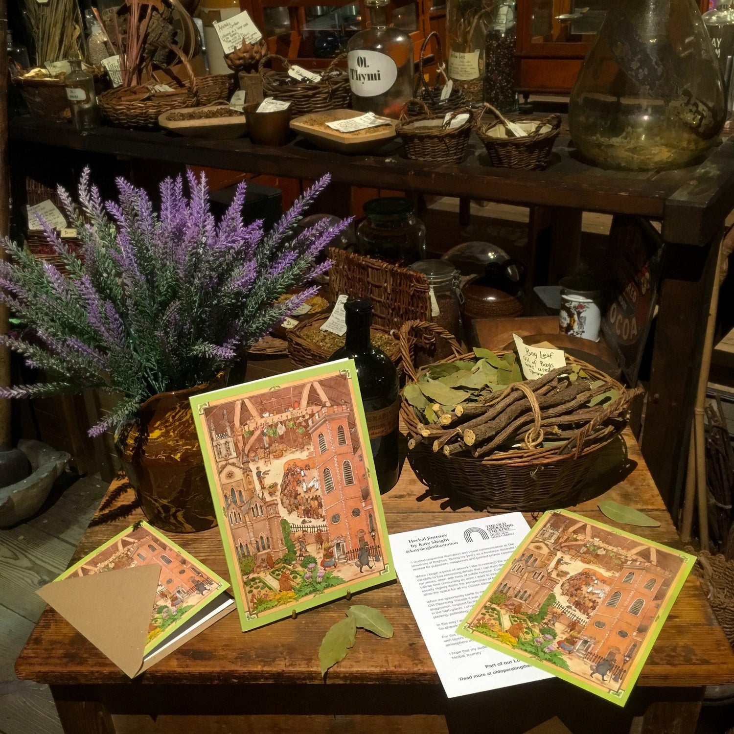 Prints and a greetings card with a design that features different historical aspects of the Old Operating Theatre, placed on a table in the herb garret