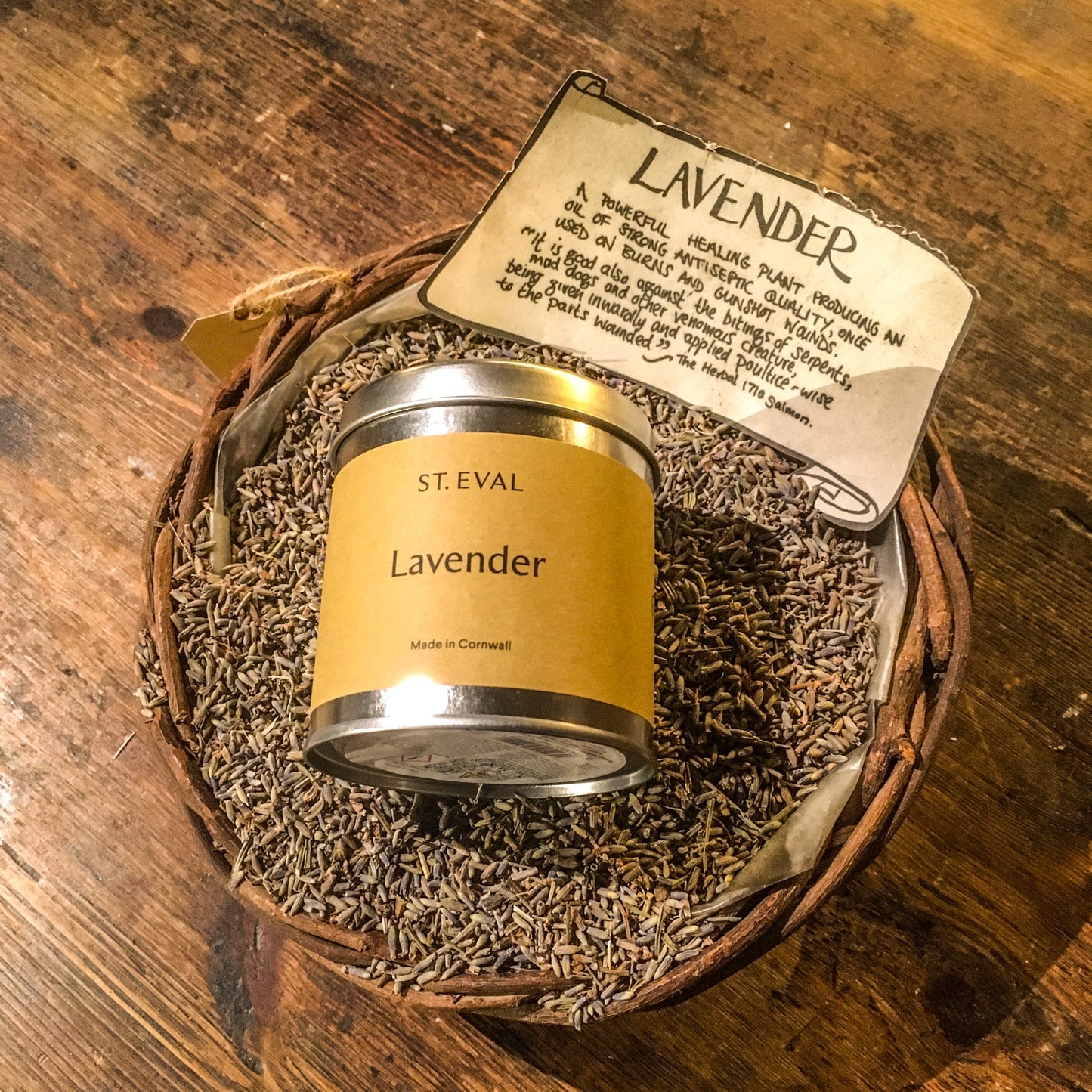 A lavender candle tin in a basket of dried lavender