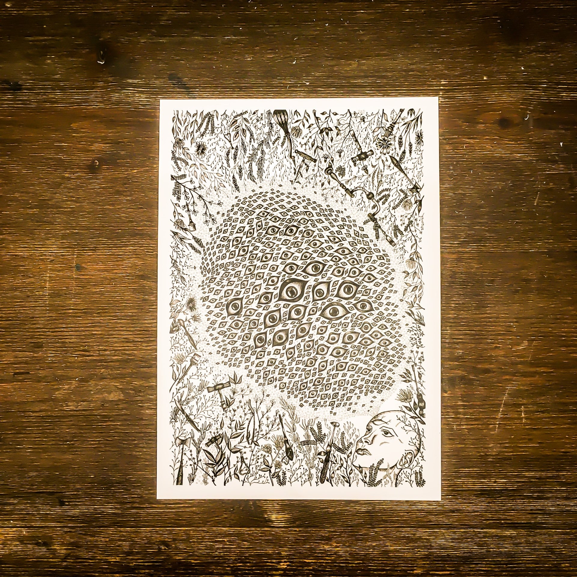 A card on a wooden surface with the trepanation and eye design