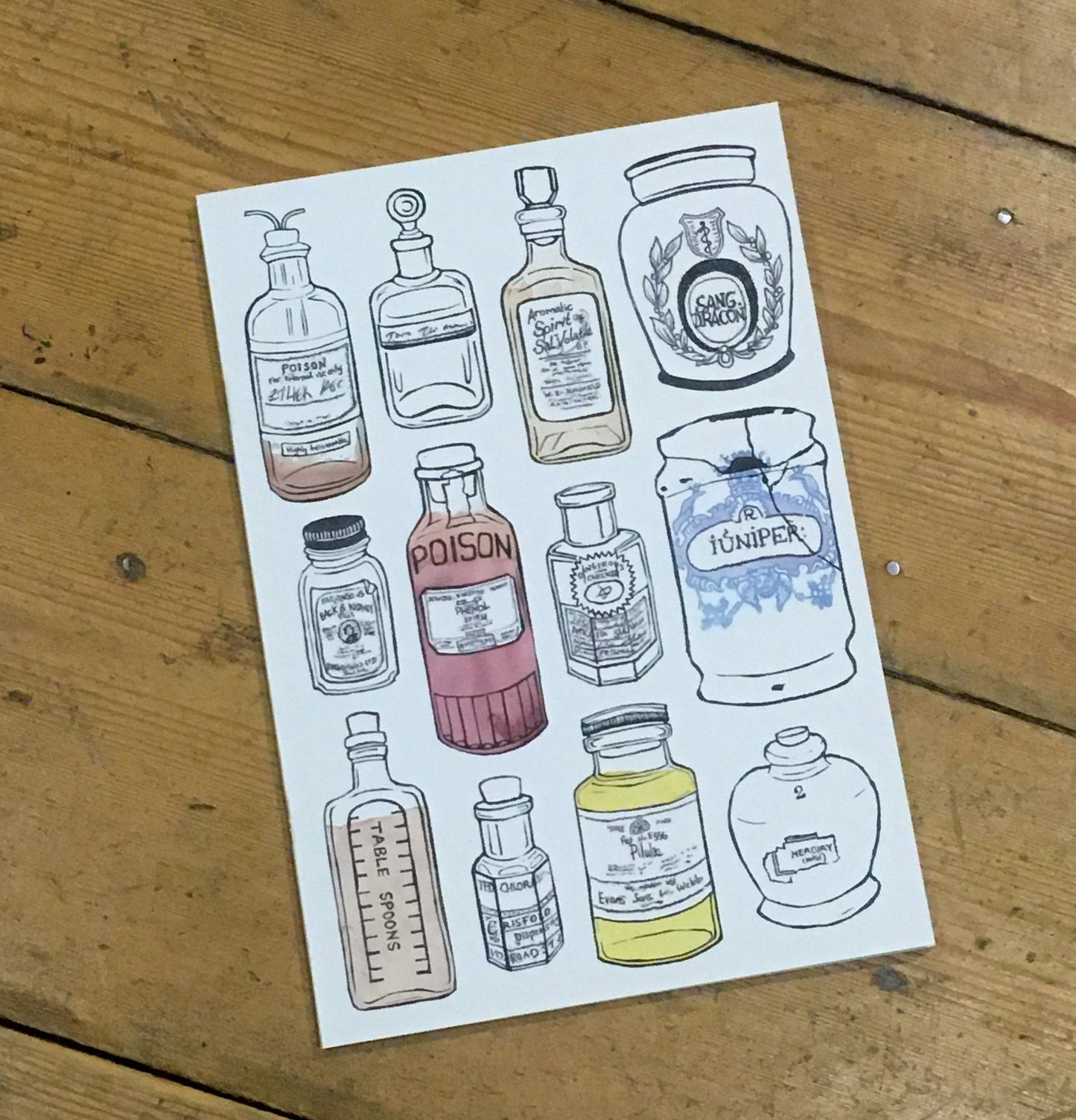 A5 notebook, off-white colour, with lino printed apothecary bottles on cover.