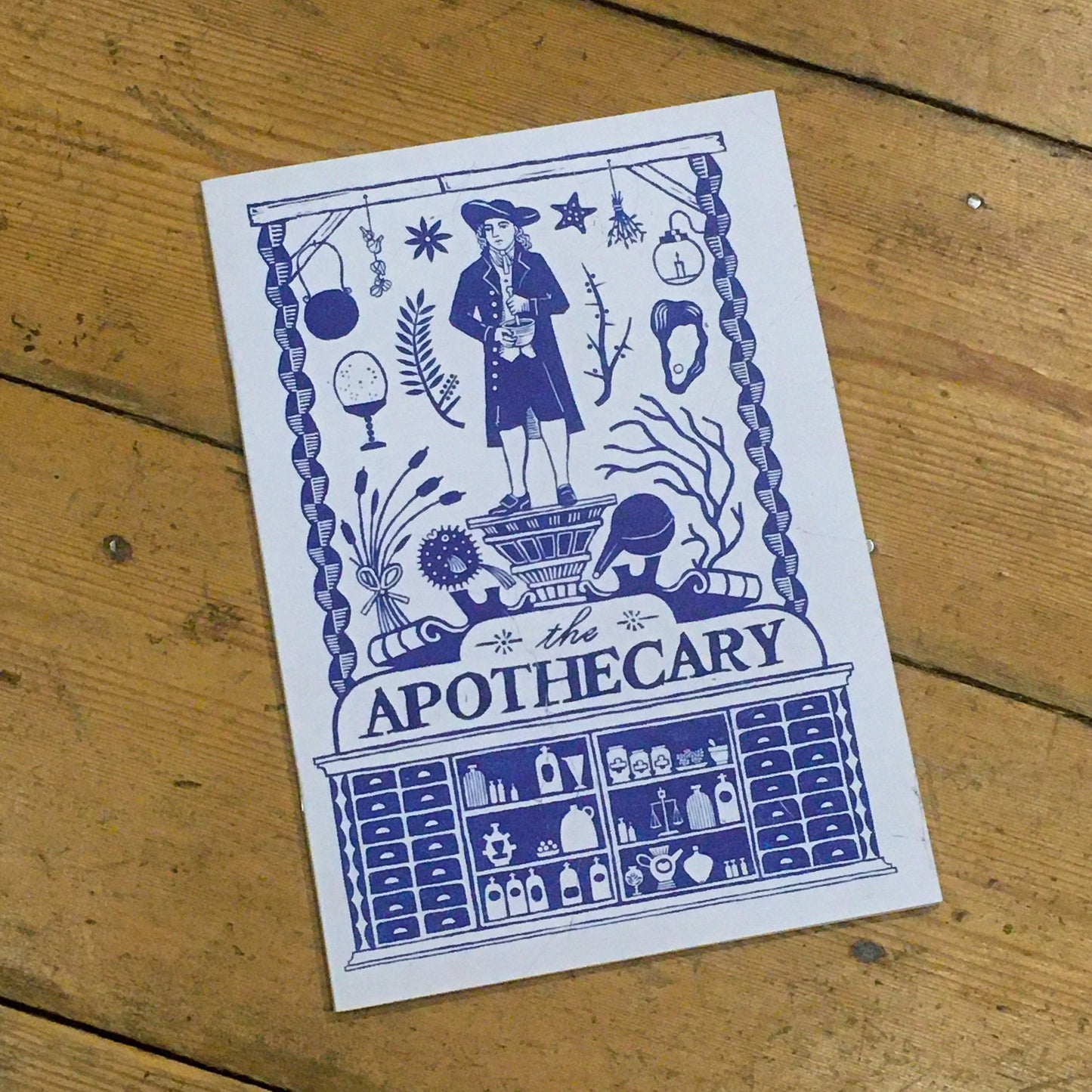 A5 notebook with blue and white apothecary design on the cover.