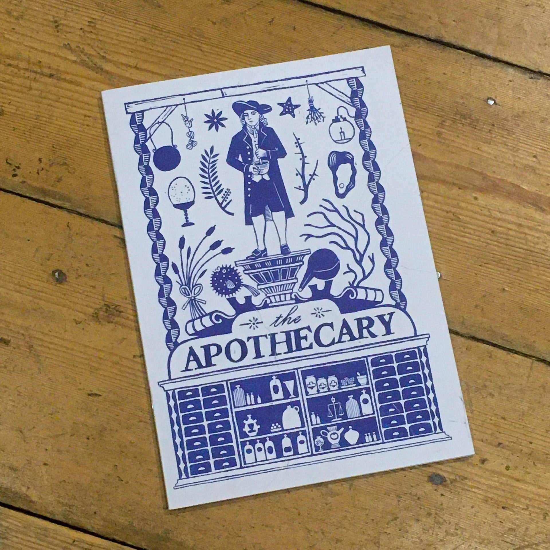 A5 notebook with blue and white apothecary design on the cover.