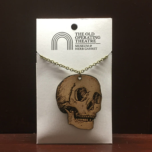 Wooden pendant in the shape of a skull, on a metal chain
