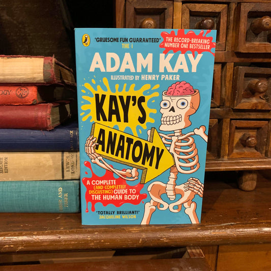 The Kay's Anatomy book displayed next to old hardback books and a small wooden chest