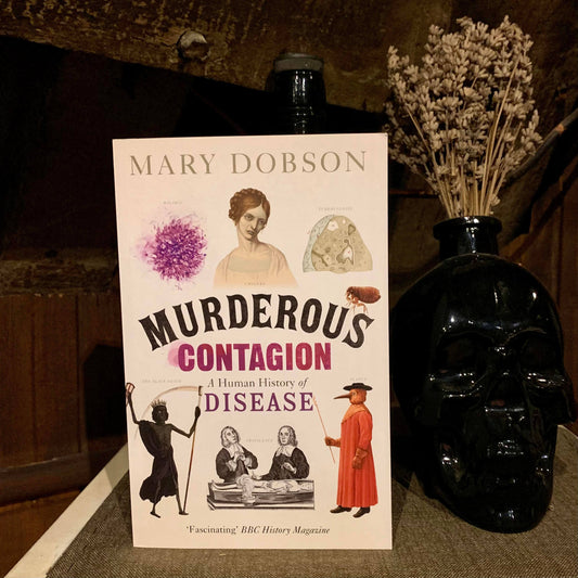 The Murderous Contagion book placed next to a black skull within the museum