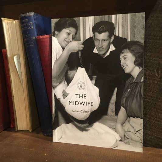The Midwife book on a shelf next to some old hardback books