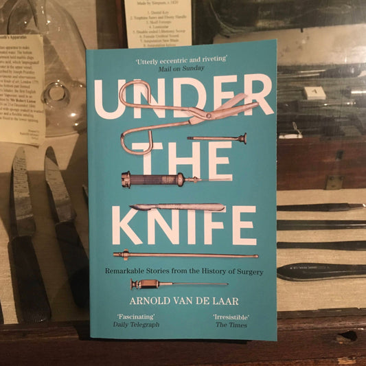 The book Under the Knife in front of a display cabinet of surgical instruments