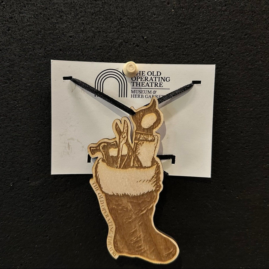 Decorative stocking with medical tools, engraved with The Old Operating Theatre, on a black background