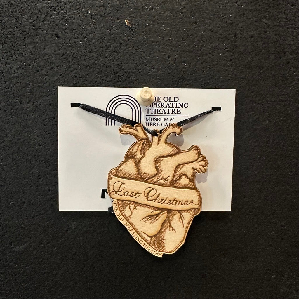 Heart-shaped ornament with 'Last Christmas' text on a black background, engraved with 'The Old Operating Theatre'