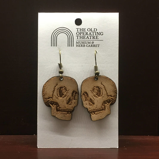 Pair of wooden earrings in the shape of a skull, on a wire hook